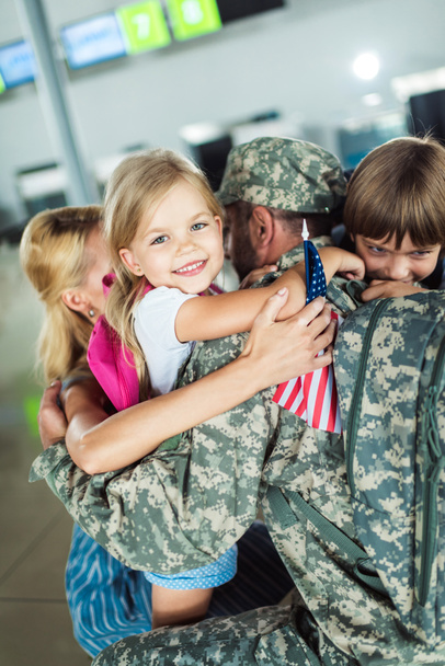 семья обнимает отца в аэропорту
 - Фото, изображение