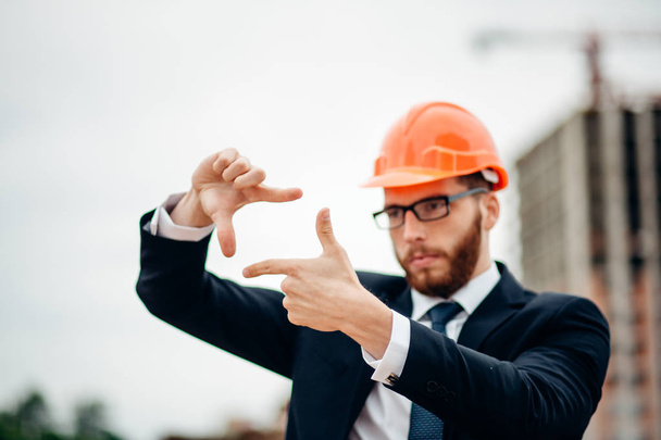senior builder in hardhats pointing outdoors - Фото, изображение