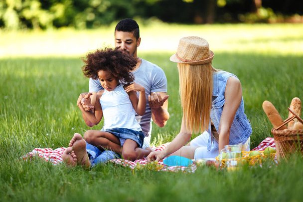 Picture of lovely couple with their daughter having picnic - Foto, imagen