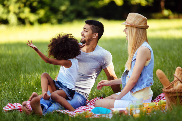 Picture of lovely couple with their daughter having picnic - Foto, imagen