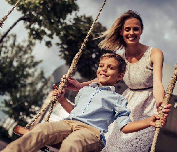 Mom with son on swing - Фото, зображення