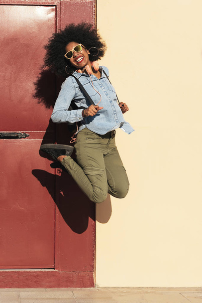 Portrait of beautiful afro american woman jumping. - Fotó, kép