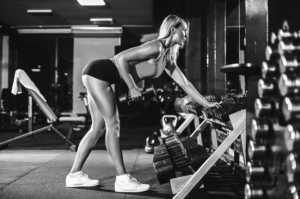 fitness blonde girl posing and exercising with dumbbell - Fotó, kép