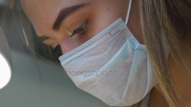 A girl in a medical mask is doing a professional manicure  - Footage, Video