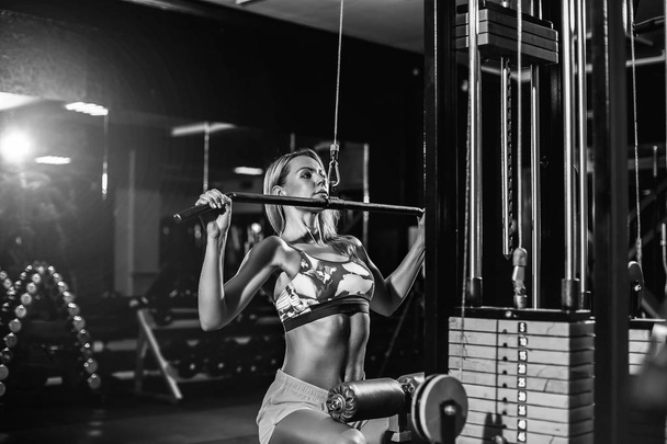 Woman training with weight-lifting training machine - Foto, Imagem