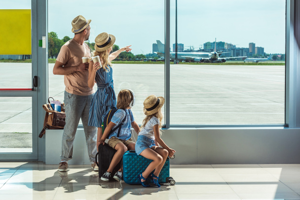 family looking out window in airport - Photo, Image