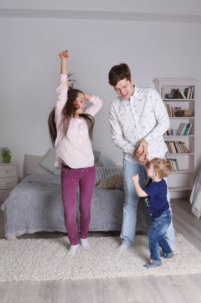glücklich schöner Vater, Mutter und kleiner Sohn tanzen im Schlafzimmer bei - Foto, Bild