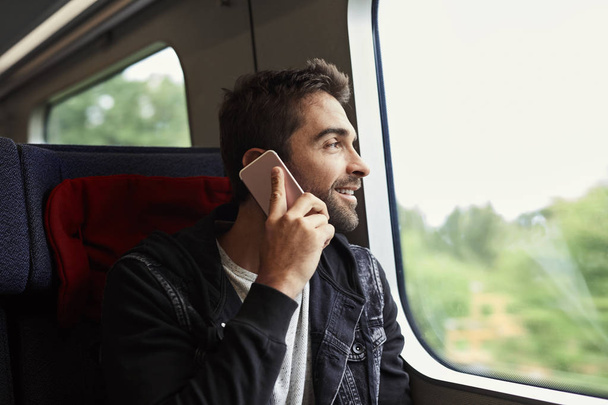 guy on train taking a call - Zdjęcie, obraz