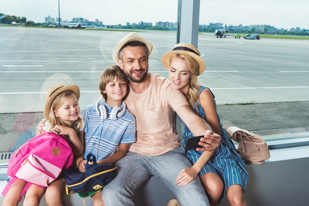 happy family taking selfie in airport - Фото, изображение