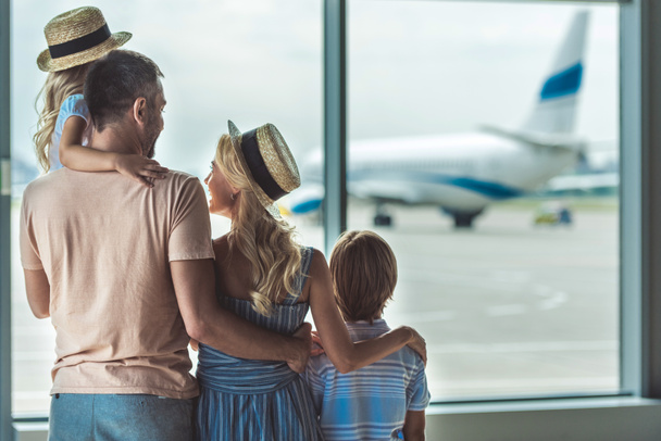 family looking out window in airport - Foto, imagen
