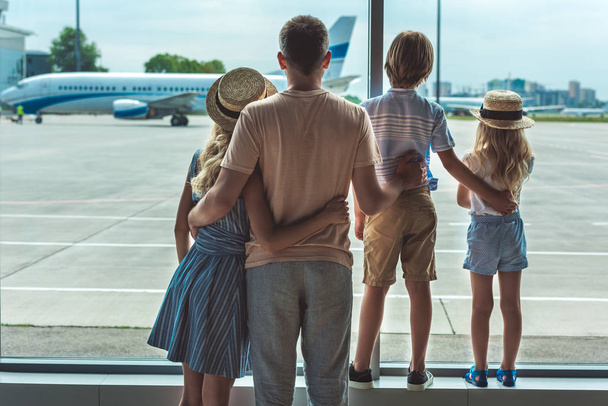 family looking out window in airport - Foto, Bild