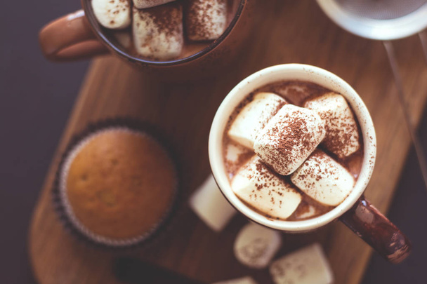 Cups with hot chocolate with marshmallow and muffins  - Foto, Imagen