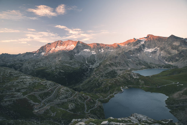 Lac alpin de haute altitude, barrages et bassins hydrographiques dans un pays idyllique avec des sommets rocheux majestueux brillants au coucher du soleil. Vue grand angle sur les Alpes
. - Photo, image