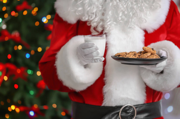 Santa Claus holding plate with cookies  - Фото, изображение