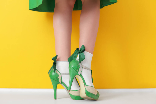 Female legs in green high heel shoes  - 写真・画像