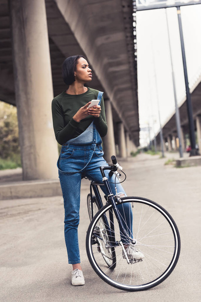 スマート フォンで自転車の女性 - 写真・画像