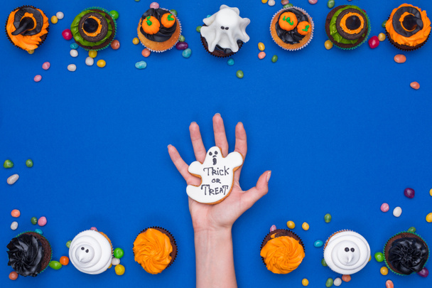 hand and halloween cupcakes - Photo, Image