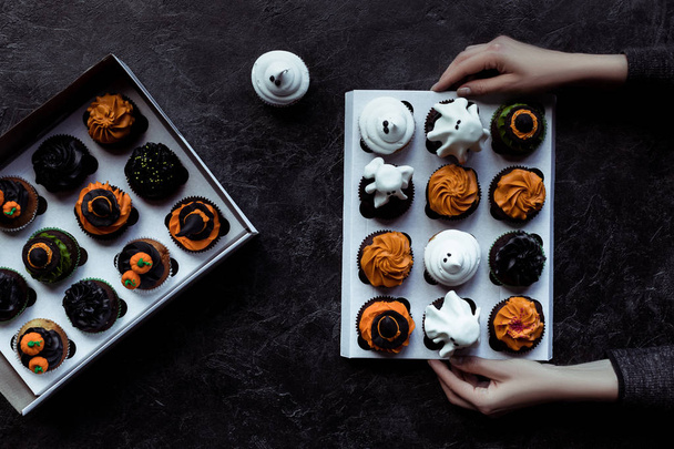 hands holding halloween cupcakes - Photo, Image
