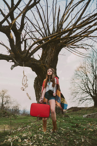 хіпстерська дівчина стоїть біля старого дерева
. - Фото, зображення