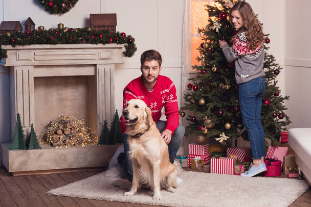 echtpaar met hond op kerst - Foto, afbeelding