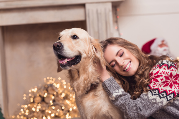 jonge vrouw en hond bij christmastime - Foto, afbeelding