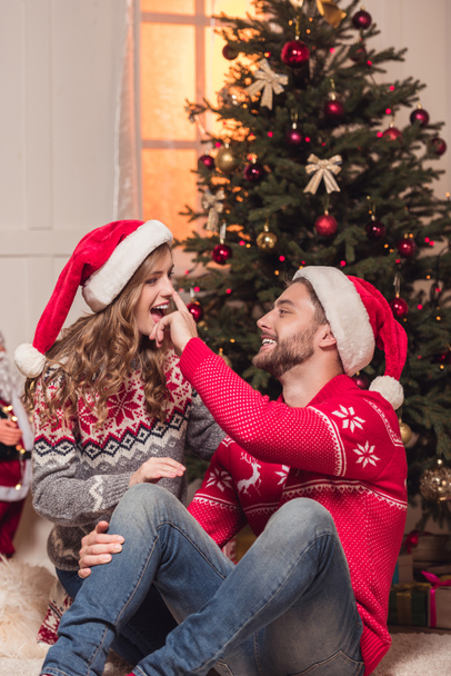 felice giovane coppia in cappelli di Babbo Natale
 - Foto, immagini