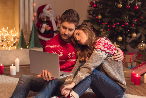 couple with laptop at christmastime - 写真・画像