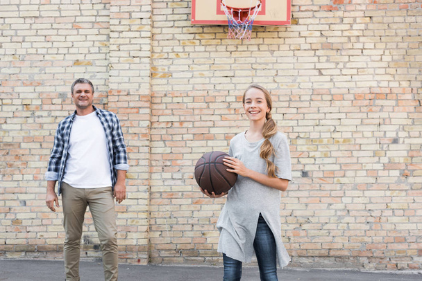 vader en dochter spelen basketbal - Foto, afbeelding