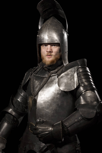 Knight in armour after battle on the black background - Fotografie, Obrázek