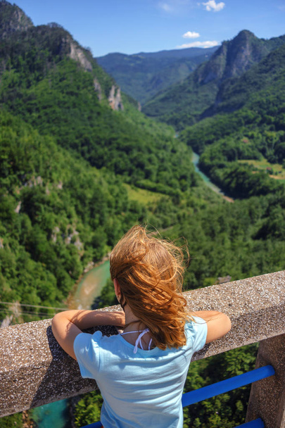 the girl looks from the bridge to the canyon - Foto, imagen