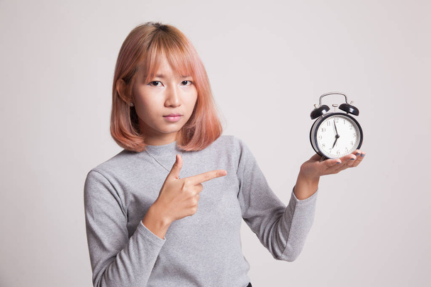 Angry young Asian woman point to a clock. - Фото, зображення