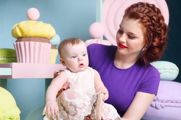 Little baby in white dress and mother pose in studio with sweet  - Photo, Image