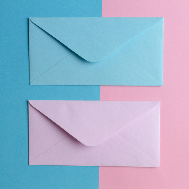 Envelopes rosa e azul sobre fundo rosa e azul colorido. Vista superior
. - Foto, Imagem
