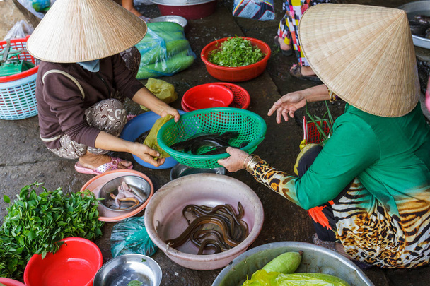 Vrouwen bereiden voedsel op een markt van de Mekong Delta in Nga-Baai, Vietnam - Foto, afbeelding