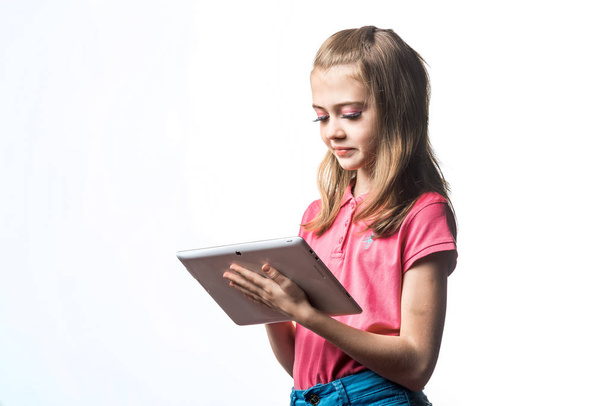 Beautiful little girl with a tablet computer in hands on a white - Zdjęcie, obraz