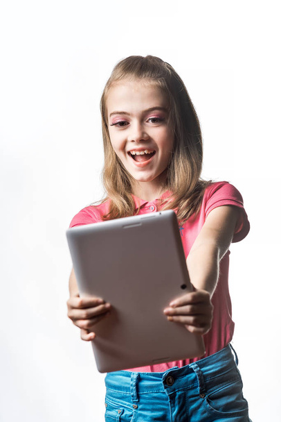 Little girl with a tablet computer on a white background. Emotio - 写真・画像