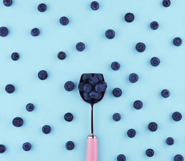 Fresh picked blueberries on blue trendy background. - Fotó, kép