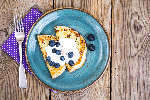 American pancakes with sauce and blueberries on wooden table top - Foto, Bild