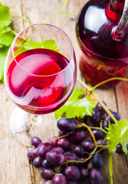 Kieliszek czerwonego wina z winogron na rustykalne drewniane tła - Zdjęcie, obraz