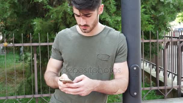 Young man talking on phone at street - Záběry, video
