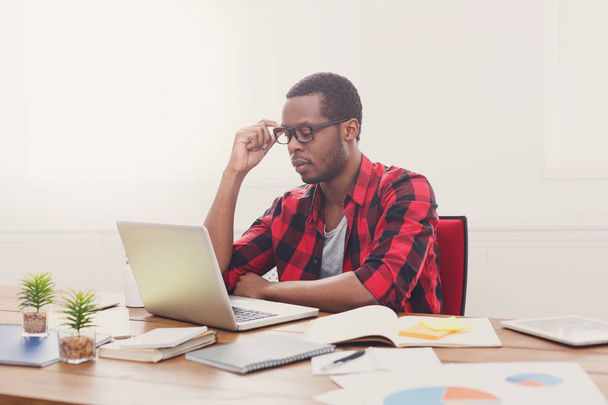 Homme d'affaires noir dans un bureau décontracté, travailler avec un ordinateur portable
 - Photo, image