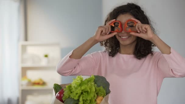 Beautiful woman bringing pepper rings to eyes, smiling, healthy eating habits - Imágenes, Vídeo