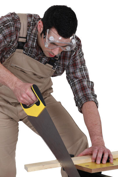 A carpenter sawing. - Фото, зображення