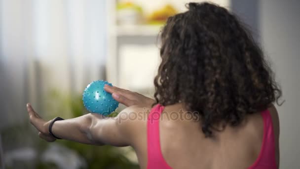Mujer joven y deportiva masajeando brazos con bola de masaje, relajando los músculos del cuerpo
 - Imágenes, Vídeo