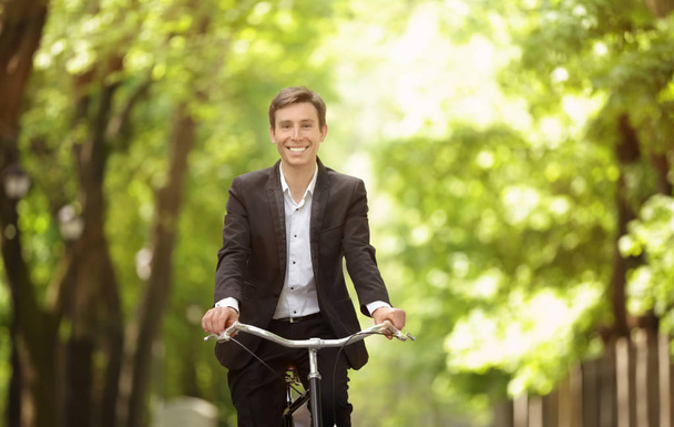 Young handsome businessman with bicycle outdoors on sunny day - Foto, afbeelding