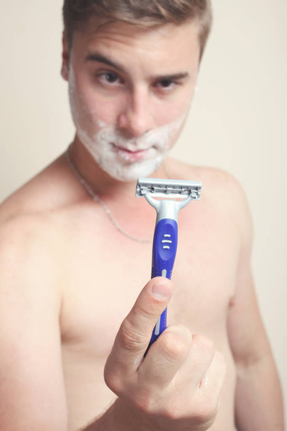 A man is holding a razor in his hand  - Photo, Image