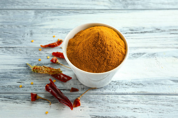 Chili powder and dried pepper pods on wooden table - Foto, afbeelding