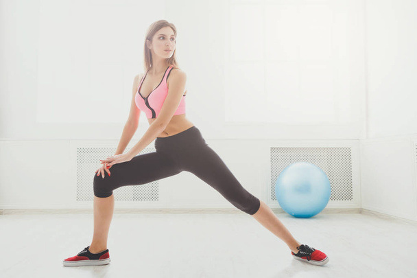 Fitness-Frau beim Stretching-Training in Innenräumen - Foto, Bild
