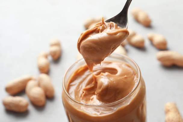 peanut butter in spoon and jar  - Fotoğraf, Görsel
