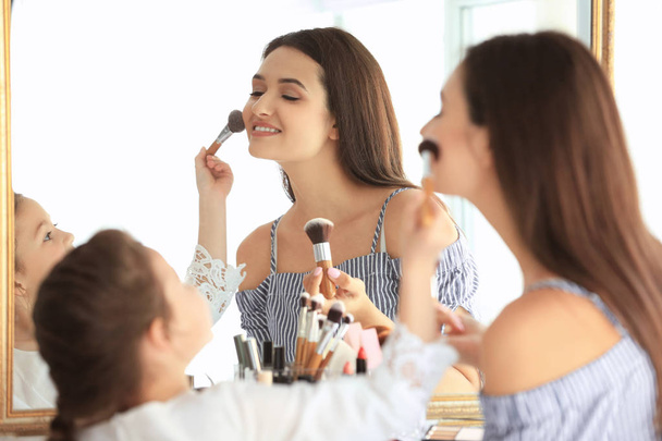 woman and daughter applying makeup  - Foto, immagini